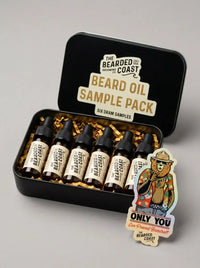 Bearded Coast Beard Oil Sample Pack with six dram dropper bottles in open black tin with gold crinkle paper and "Only You Can Prevent Beardruff" holographic sticker — beard oil sampler gift set