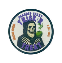 Round tin of Bearded Coast “Trick ’R Treat” beard butter featuring a skeleton in a hood holding a green candy apple.