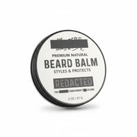 Round tin of “Redacted” beard balm labeled “Styles & Protects” with Full Transparency Cologne scent, 2 oz size.
