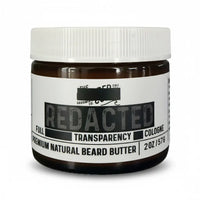 "Redacted" scent beard butter jar with white label, amber glass, and bold black text reading “Full Transparency Cologne.”