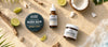 Bearded Coast Beard care products including balm, oil, and butter on a sandy background with limes and coconuts.