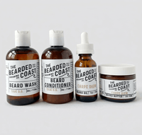Bearded Coast Carpe Diem Complete Beard Kit featuring four amber glass and plastic bottles — Beard Wash 4oz, Beard Conditioner 4oz, Unscented Beard Oil 1oz, and Beard Butter 2oz — with white labels on a clean light gray background
