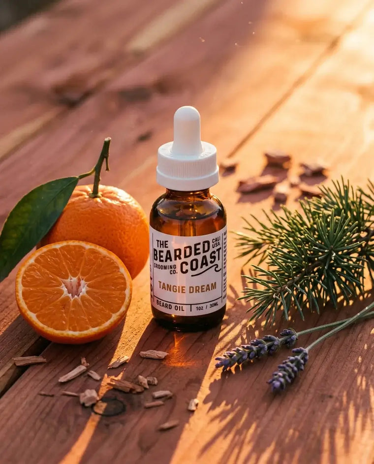 Amber dropper bottle of Bearded Coast Grooming Co. Tangie Dream Beard Oil, 1oz/30ml, on a warm cedar wood surface surrounded by fresh tangerines, lavender sprigs, pine needles, and cedar chips in golden sunset light.